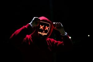 Hooded man in red light up mask