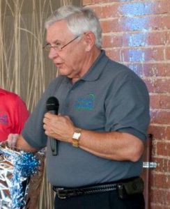 Older man speaking into a microphone