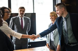 People in a meeting shaking hands and smiling