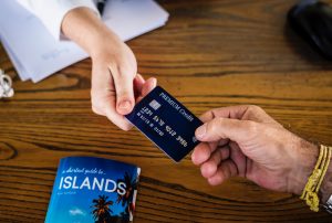 Lady handing man credit card to pay