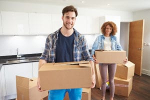 Couple Moving Into New Home And Unpacking Boxes