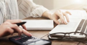 Auditing company. Business woman checking balance. Internal Revenue Service inspects document with laptop computer and calculator, copy space