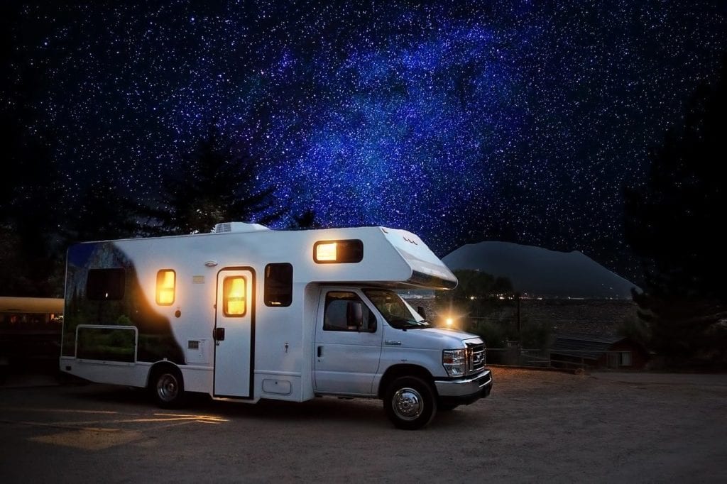 recreational vehicle parked with the nighsky in the background