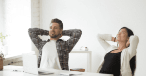 diverse couple relaxing with hands behind their heads in a white pristine room