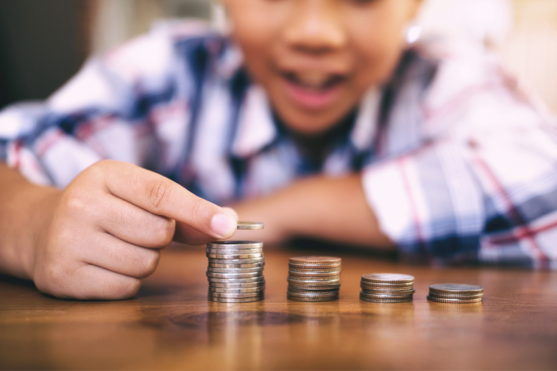 Young boy counting coins on table