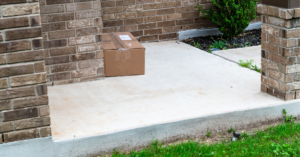 brown package left on doorstep with concrete brick green lawn